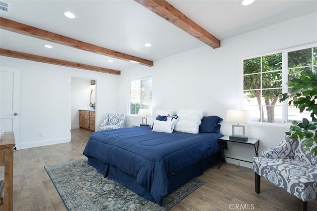 bedroom featuring beam ceiling, multiple windows, and hardwood / wood-style flooring