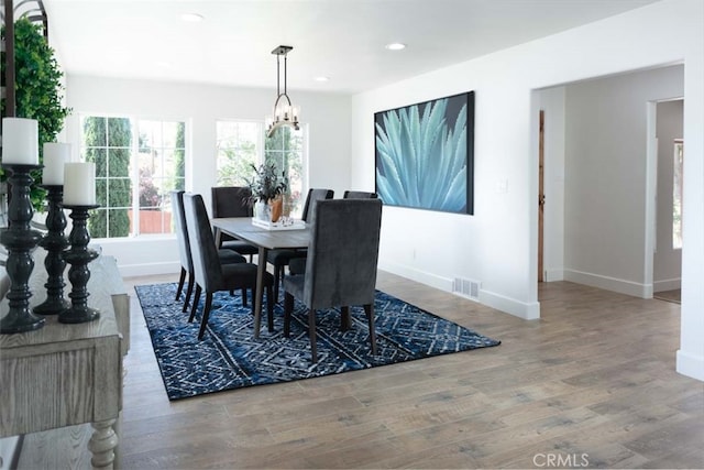 dining room with an inviting chandelier and hardwood / wood-style flooring