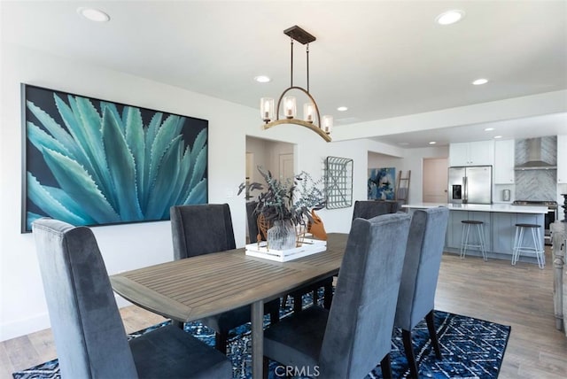 dining space with light hardwood / wood-style floors and an inviting chandelier