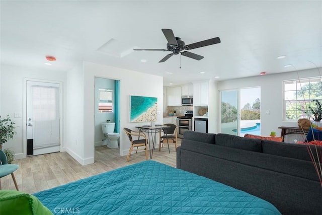 bedroom featuring ceiling fan, access to exterior, light wood-type flooring, and ensuite bathroom