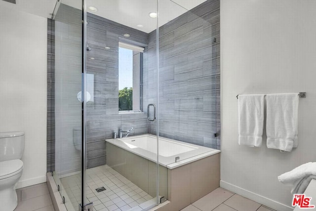 bathroom featuring tile walls, tile patterned flooring, toilet, and plus walk in shower