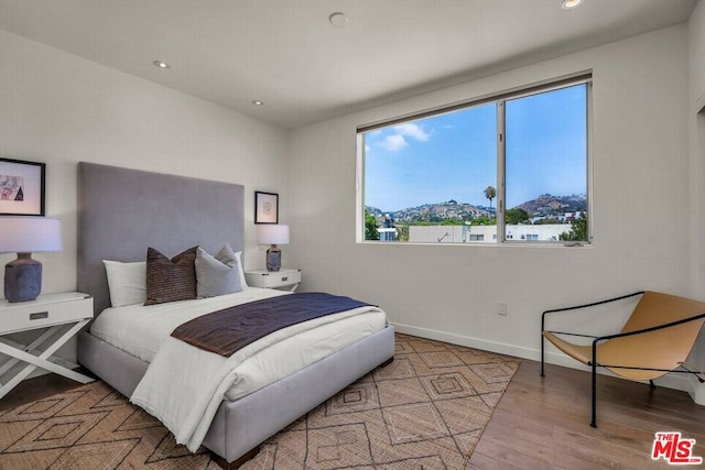 bedroom featuring light wood-type flooring and a mountain view