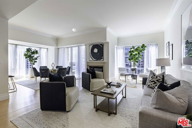 living room featuring light wood-type flooring, plenty of natural light, and crown molding