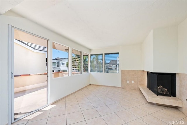 unfurnished living room featuring light tile patterned floors and a tiled fireplace