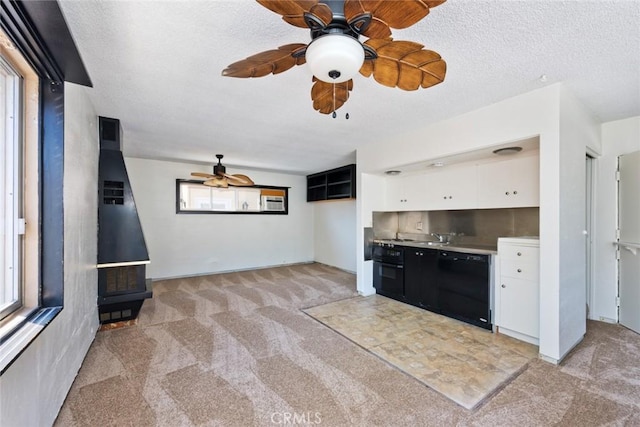 kitchen featuring white cabinetry, light colored carpet, plenty of natural light, and black appliances