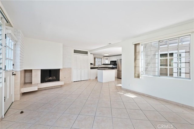 unfurnished living room with sink and light tile patterned flooring