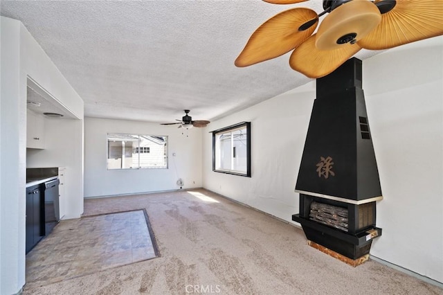 unfurnished living room featuring light carpet, ceiling fan, and a textured ceiling