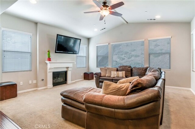 carpeted living room with lofted ceiling, ceiling fan, and a wealth of natural light