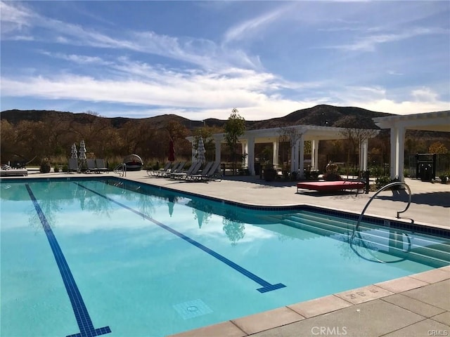 view of swimming pool featuring a mountain view and a patio area