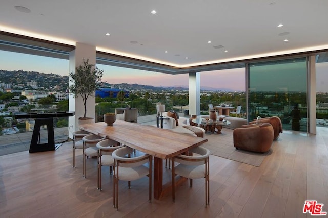 dining space with light wood-type flooring and floor to ceiling windows