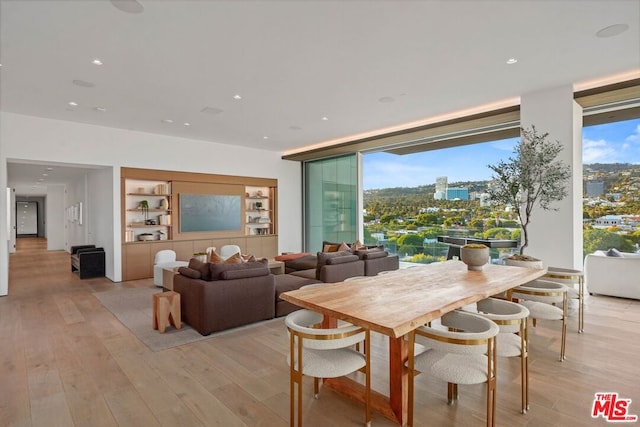 dining space featuring a wealth of natural light, built in shelves, and light wood-type flooring