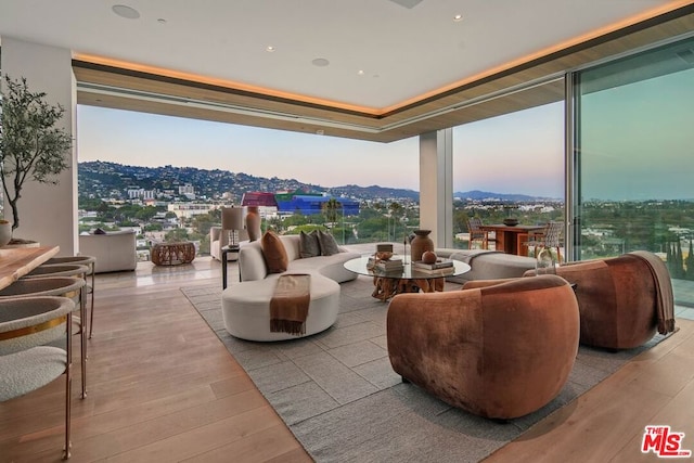 living room with light hardwood / wood-style floors and a wall of windows