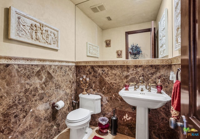 bathroom with tile walls and toilet