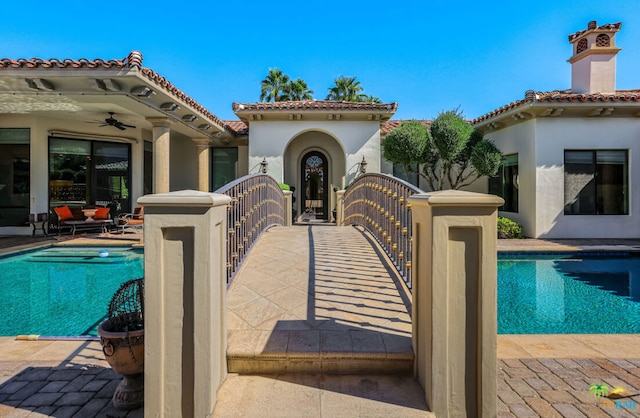 view of pool with a patio and ceiling fan