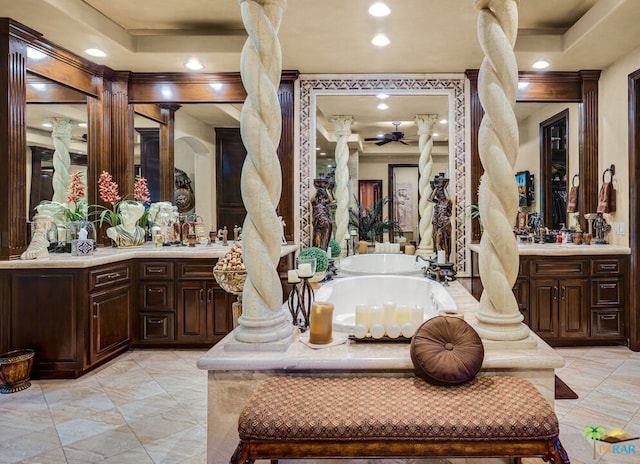 bathroom with a bath, a raised ceiling, and vanity