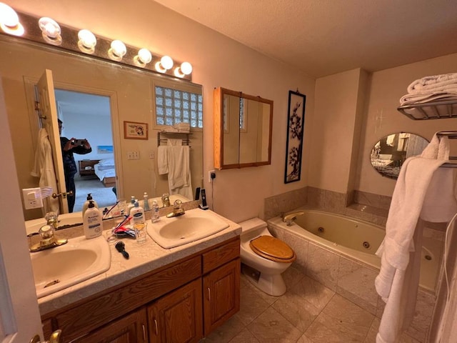 bathroom with tile patterned flooring, vanity, a relaxing tiled tub, and toilet