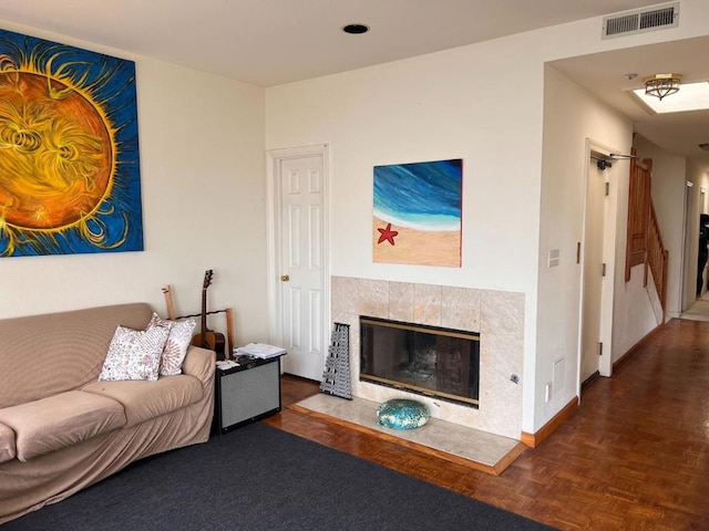 living room featuring dark parquet flooring and a fireplace