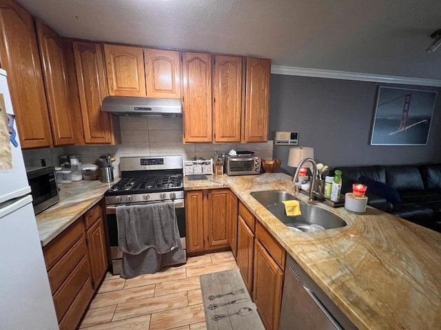 kitchen with tasteful backsplash, sink, ornamental molding, and appliances with stainless steel finishes