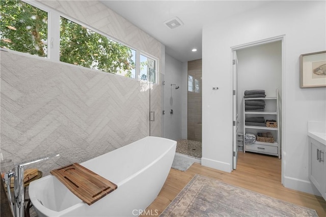 bathroom with vanity, hardwood / wood-style floors, and independent shower and bath