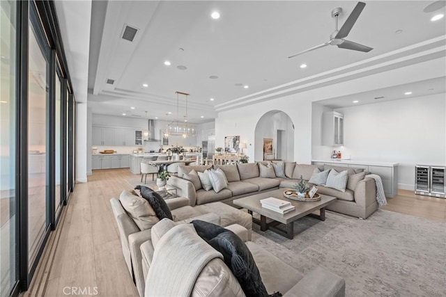 living room with ceiling fan and light hardwood / wood-style flooring