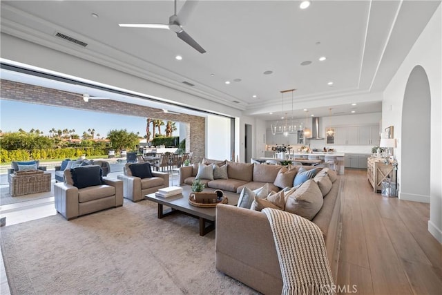 living room featuring ceiling fan and light hardwood / wood-style flooring