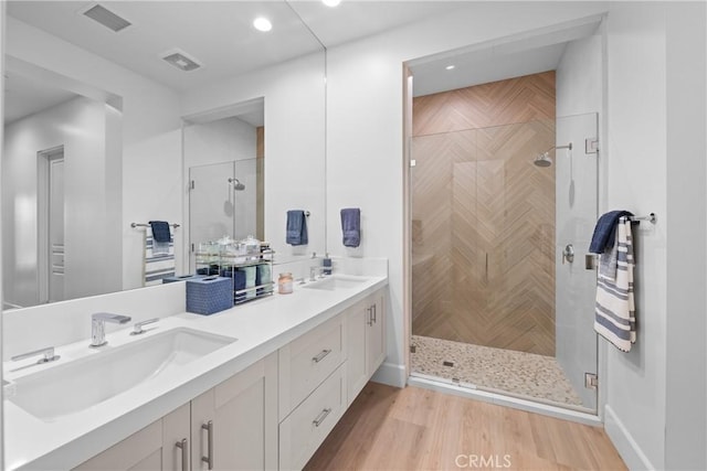 bathroom with vanity, an enclosed shower, and hardwood / wood-style floors