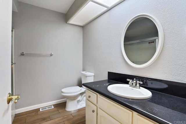 bathroom featuring wood-type flooring, vanity, and toilet