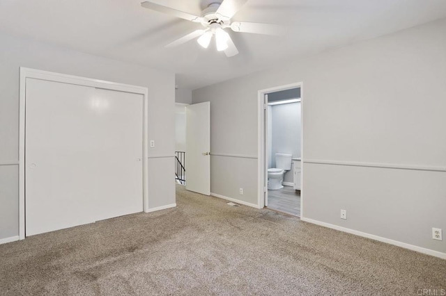 unfurnished bedroom with carpet flooring, a closet, ensuite bath, and ceiling fan