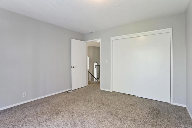 unfurnished bedroom featuring carpet flooring and a closet