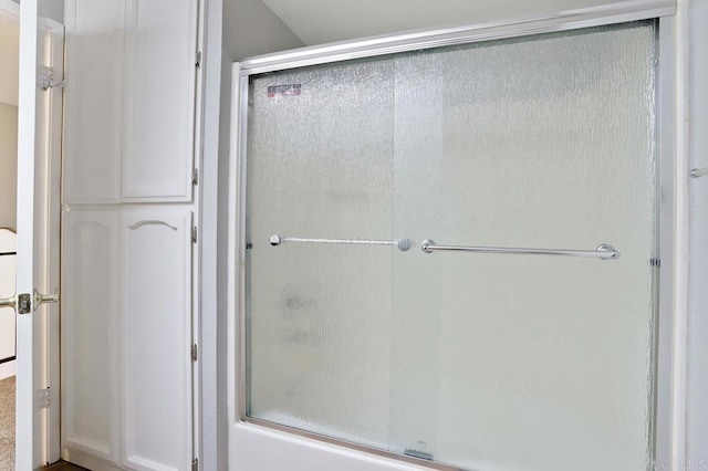 bathroom with shower / bath combination with glass door