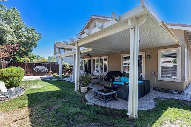 back of house featuring an outdoor living space, ceiling fan, a yard, and a patio