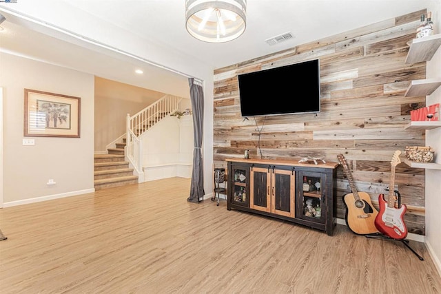 living room featuring wooden walls and light hardwood / wood-style flooring