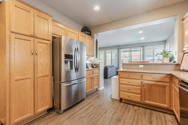 kitchen featuring light hardwood / wood-style floors, kitchen peninsula, stainless steel appliances, and light brown cabinets