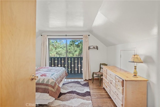 bedroom featuring lofted ceiling, access to exterior, and light wood-type flooring