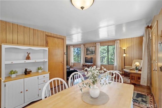 dining space featuring wooden walls and hardwood / wood-style floors