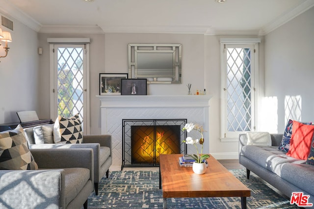 living room with a tile fireplace, hardwood / wood-style floors, and ornamental molding