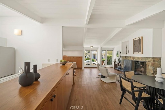 dining room featuring a fireplace, french doors, beamed ceiling, and hardwood / wood-style flooring