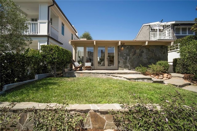 back of property with a yard and french doors