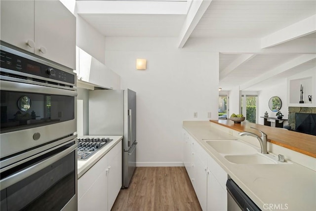 kitchen with sink, white cabinetry, and stainless steel appliances