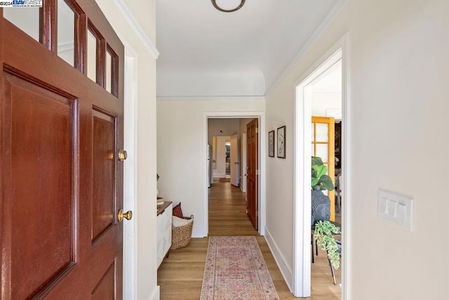 foyer entrance featuring crown molding and light hardwood / wood-style flooring