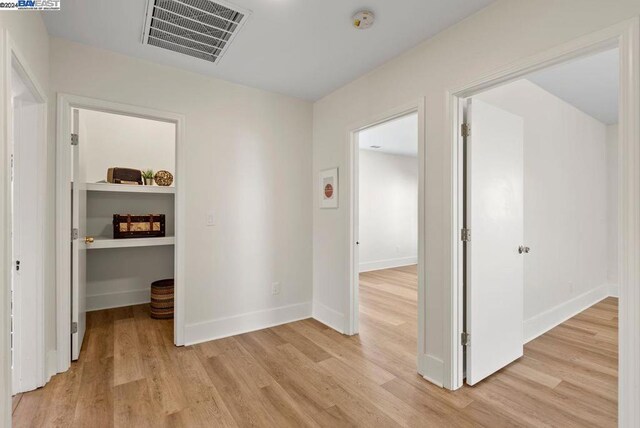 hallway with light hardwood / wood-style floors