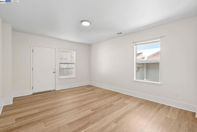 unfurnished room with light wood-type flooring and plenty of natural light