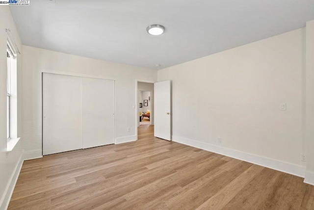 unfurnished bedroom featuring light hardwood / wood-style floors and a closet