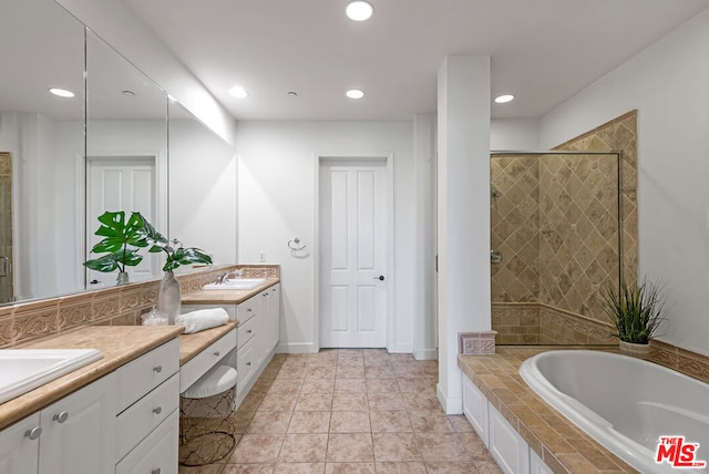 bathroom featuring tile patterned flooring, shower with separate bathtub, and vanity