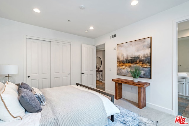 carpeted bedroom with connected bathroom and a closet