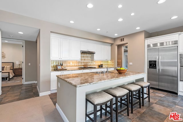 kitchen featuring a center island with sink, white cabinets, and appliances with stainless steel finishes