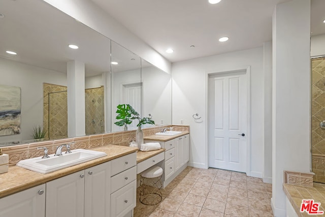 bathroom featuring a tile shower, tile patterned floors, and vanity