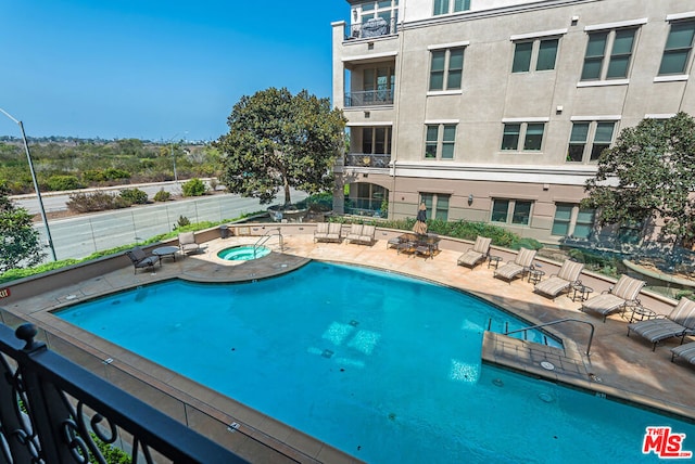 view of pool featuring a patio area and a community hot tub