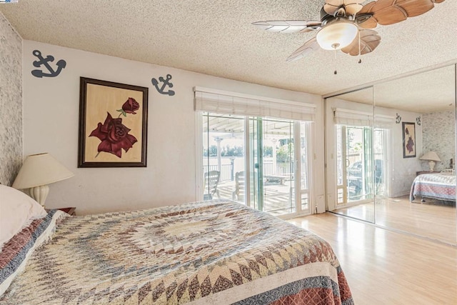 bedroom with wood-type flooring, a textured ceiling, access to exterior, and ceiling fan