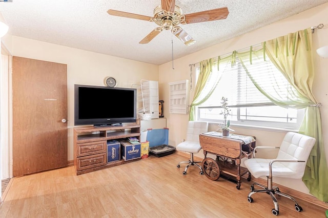 home office with wood-type flooring, a textured ceiling, and ceiling fan